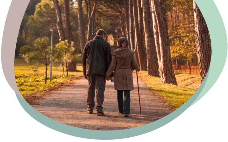 old couple walking through a leafy park